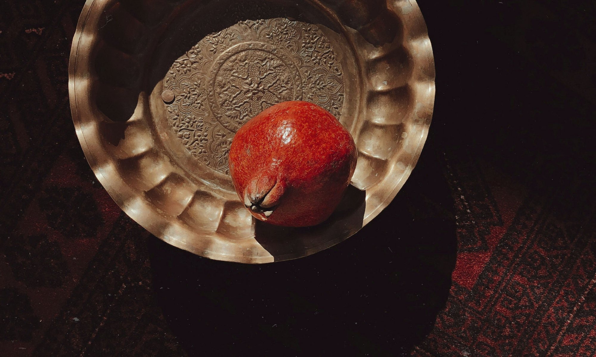 Pomegranate in an engraved brass bowl, Sensorium Arabian Stories